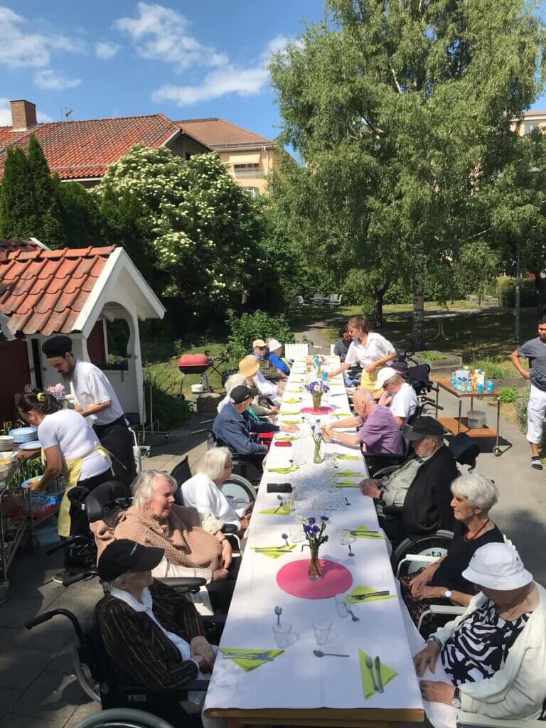 Långbord i midsommar i trädgården