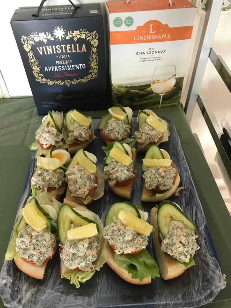 Snittar med skagenröra upplagda på fat, att serveras med vin